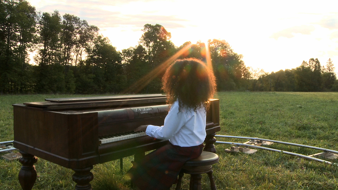 nichola feldman-kiss, after, Africa \ “So long, Farewell” (sunset) / a yard of ashes (continuous cross dissolve) / “Oh! How I hate to get up in the morning!” (sunrise) (2012).  Still of a durational performance.